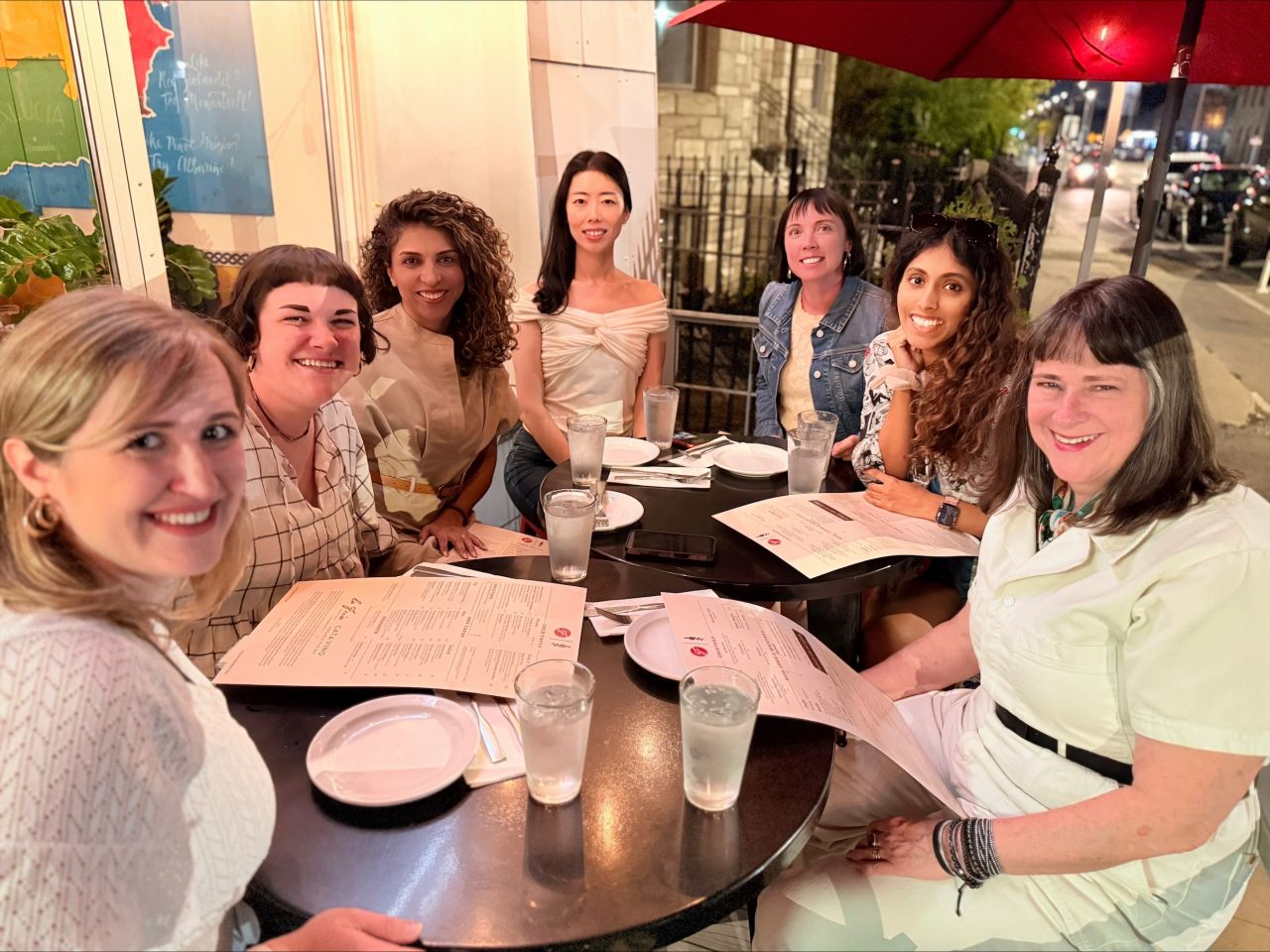 A group gathered around an outdoor restaurant table.