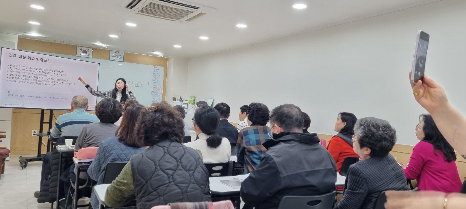 An instructor presents to a classroom of seated participants.