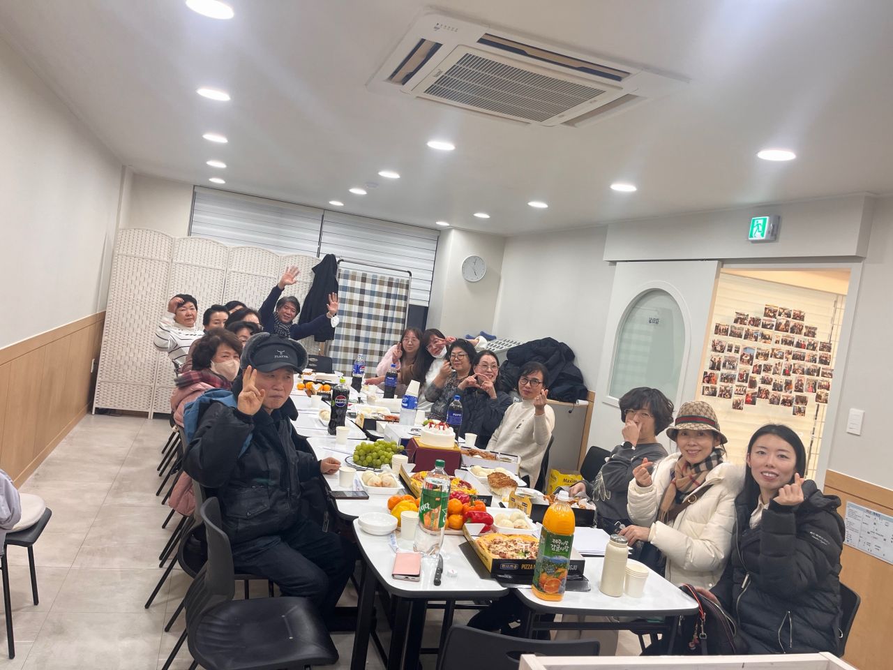 A group gathers around a long table for a shared meal.