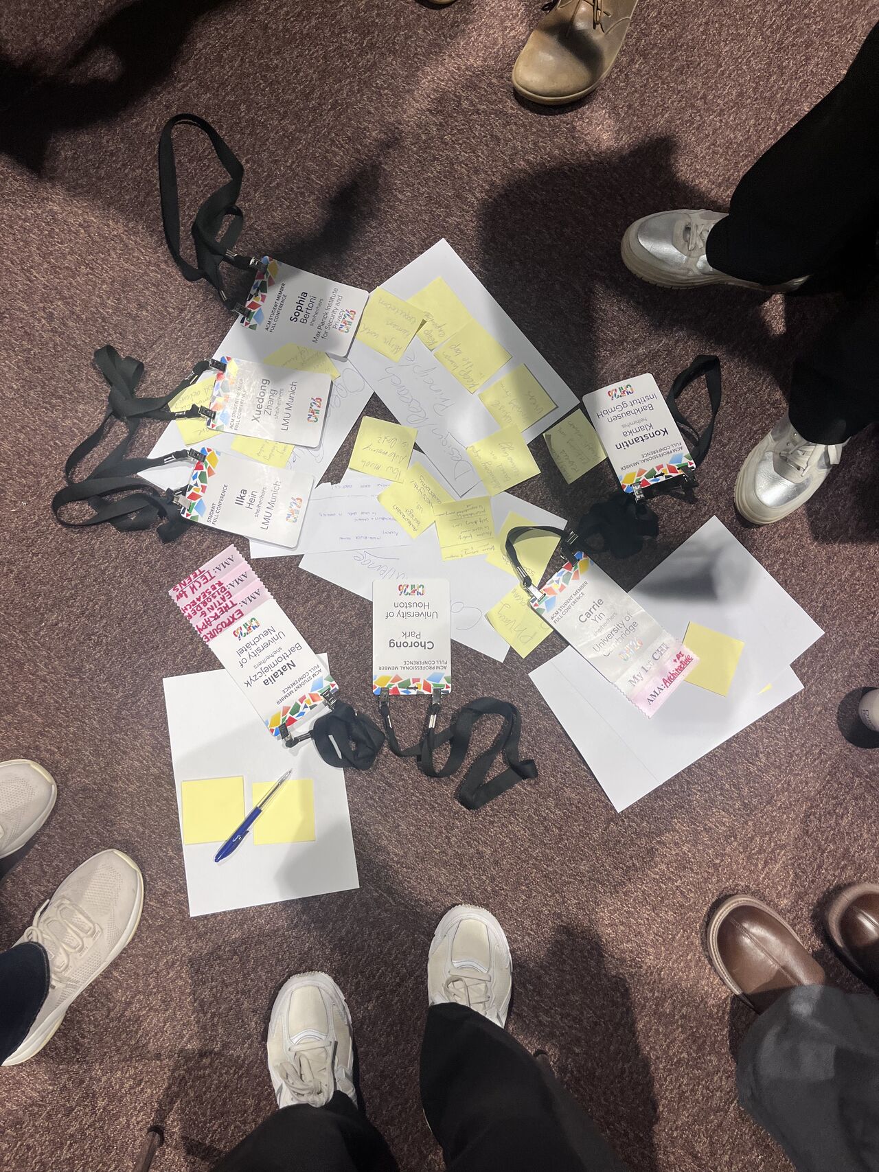 Handwritten notes and sticky notes lie between participants' chairs.