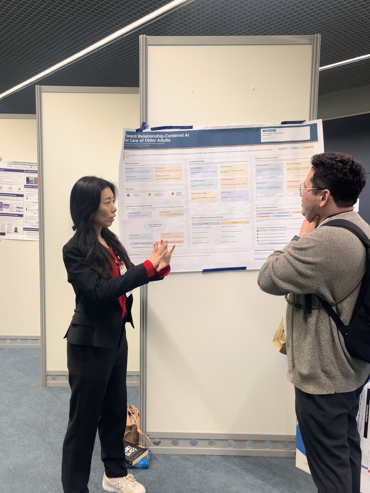 A researcher discusses a poster with another conference attendee.