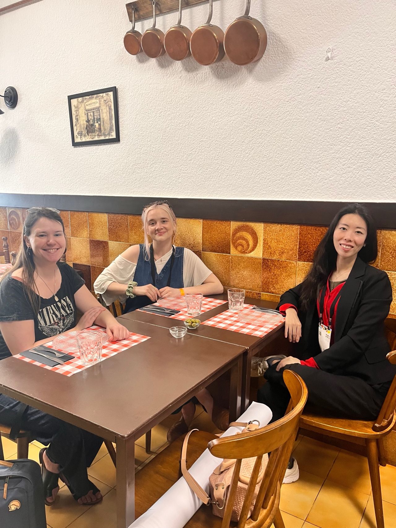 Three attendees sit together at a restaurant table.