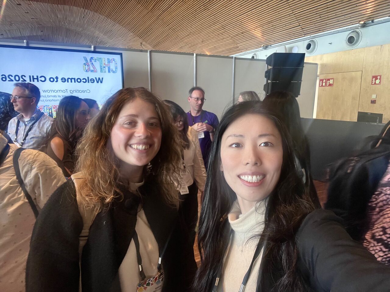 Two attendees take a photograph inside the conference venue.
