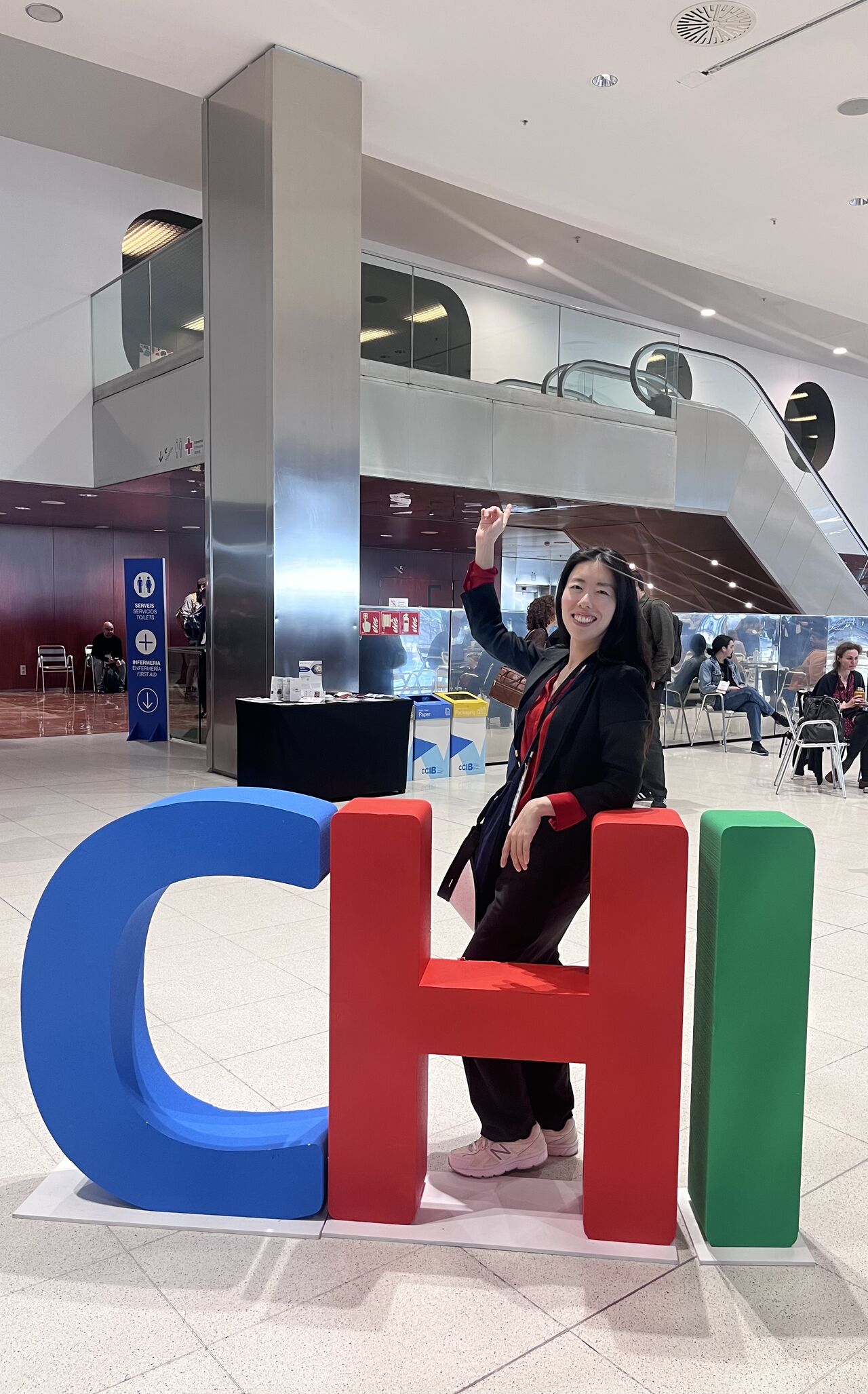 An attendee poses behind large colorful CHI letters.