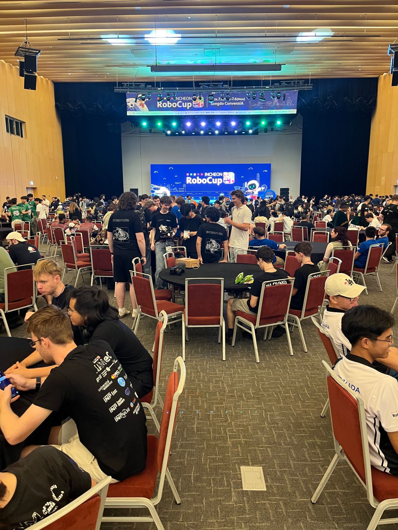 Attendees gather around tables in a large banquet hall.