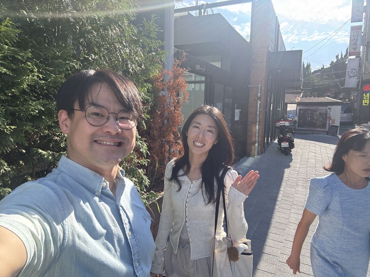 Visitors take an outdoor photograph near trees and buildings.