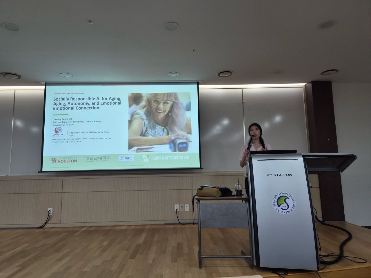 A presenter introduces a talk on socially responsible AI for aging and emotional connection.