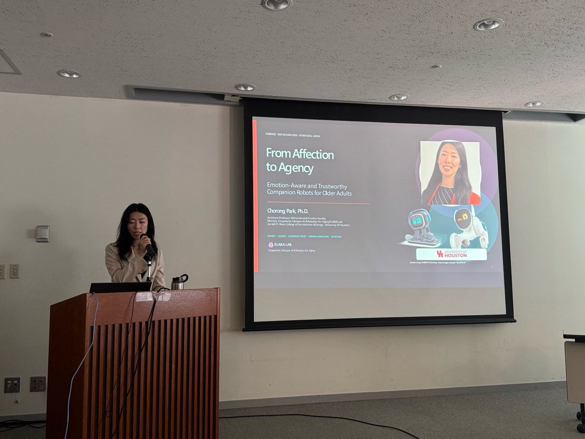 A presenter stands beside a From Affection to Agency title slide.