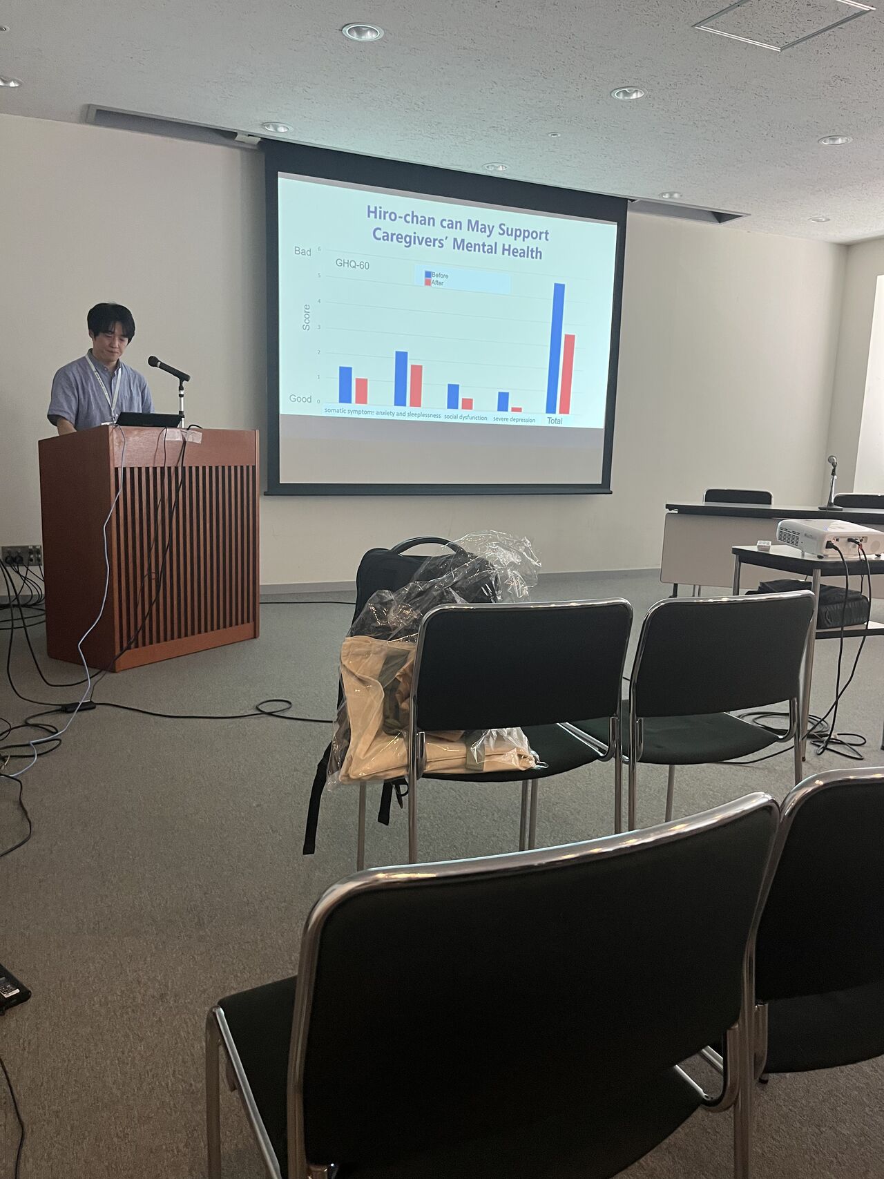 A speaker presents a slide containing a bar chart.