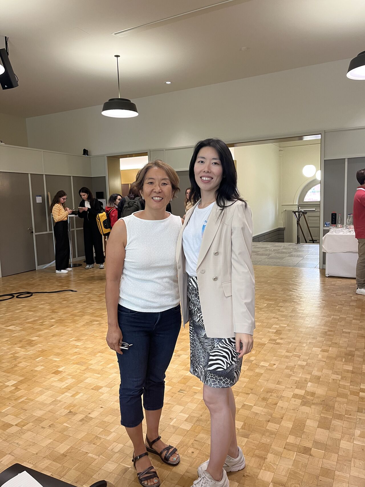 Two participants pose together inside the event venue.
