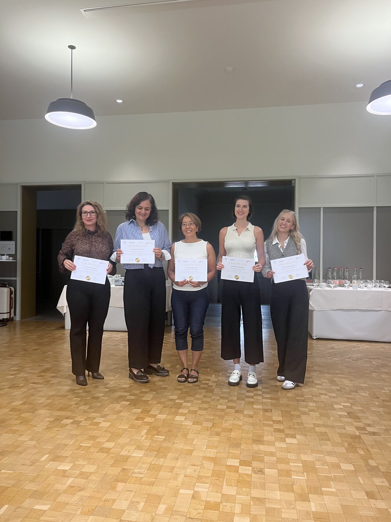 Another group of participants poses while holding certificates.