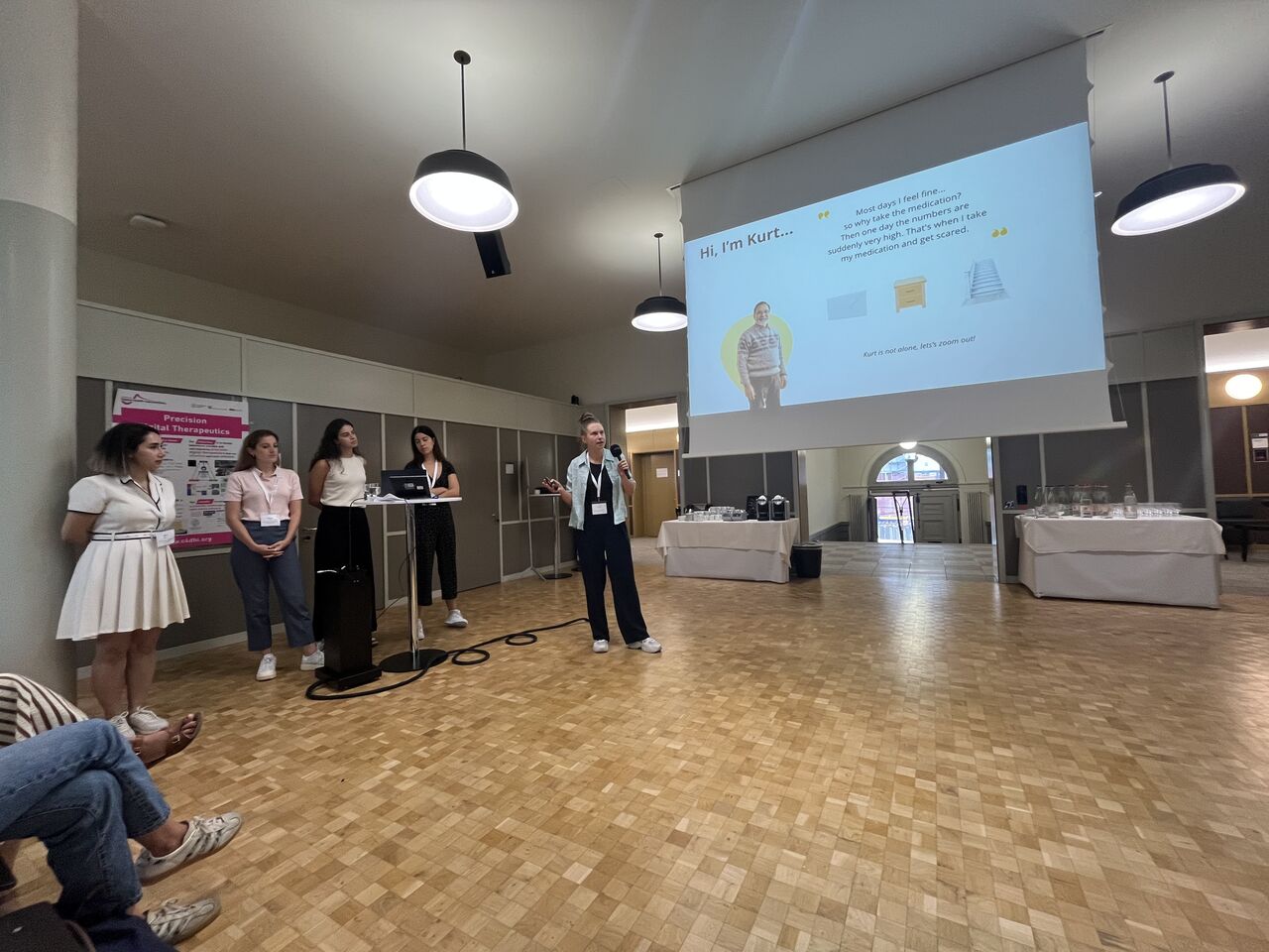 A group stands beside a projected presentation screen.