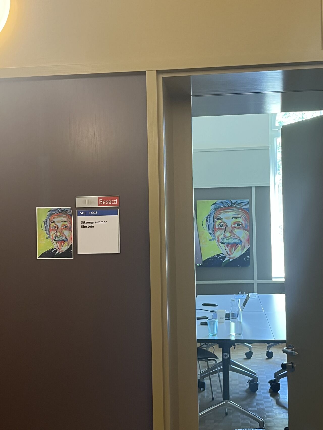 A doorway displays portrait illustrations and a view into an adjoining room.