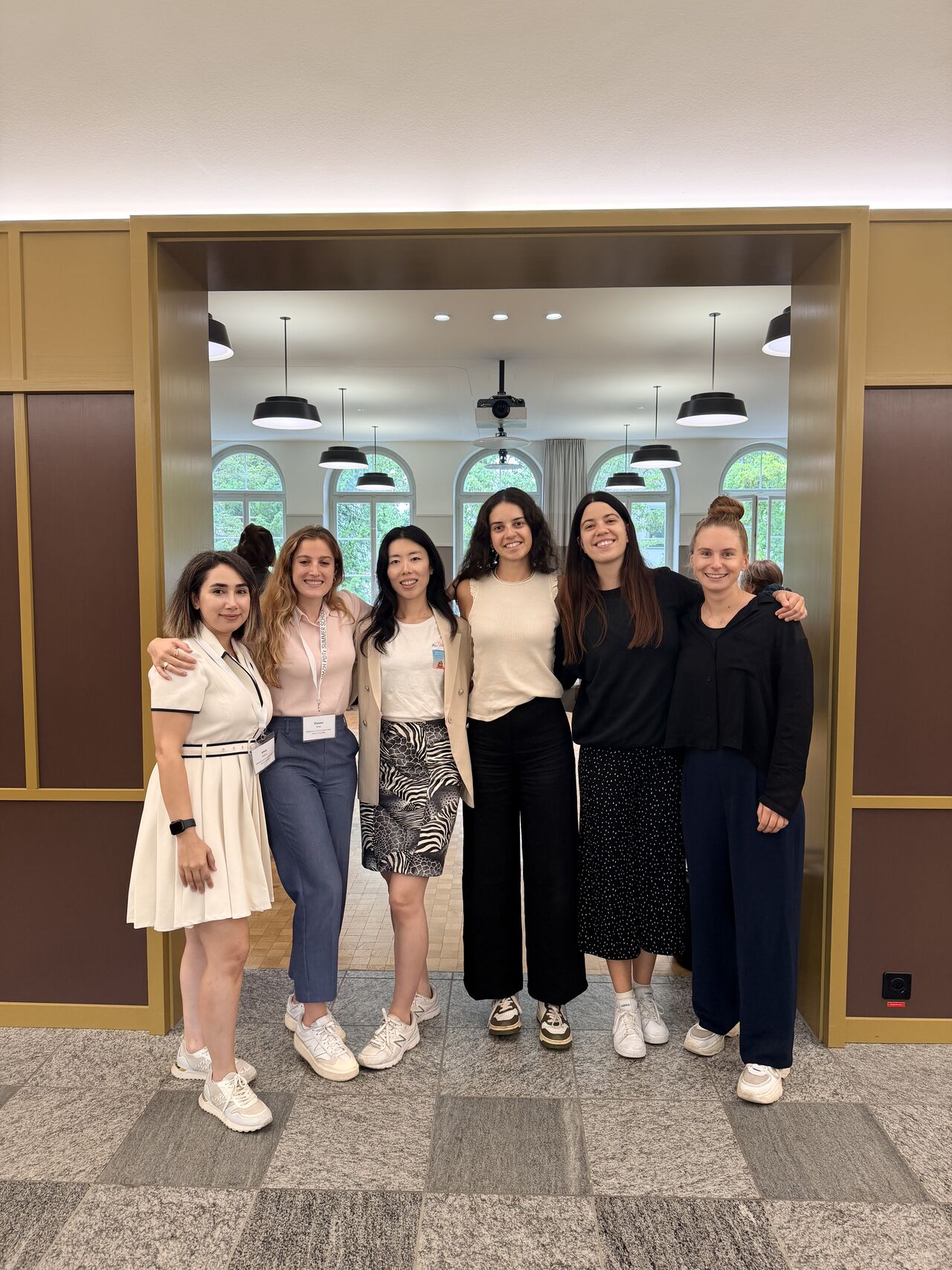 Six participants pose together in a doorway.