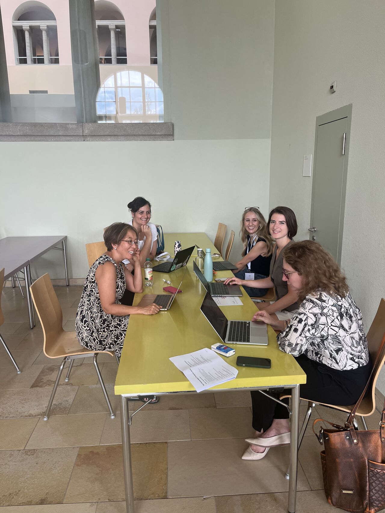 Participants sit together around a yellow table.